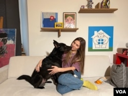 Exiled Russian journalist Ekaterina Fomina and her rescue dog, Cooper, have lived in three countries and seven apartments since Fomina fled her home country shortly after the full-scale invasion of Ukraine in 2022. (Liam Scott/VOA)