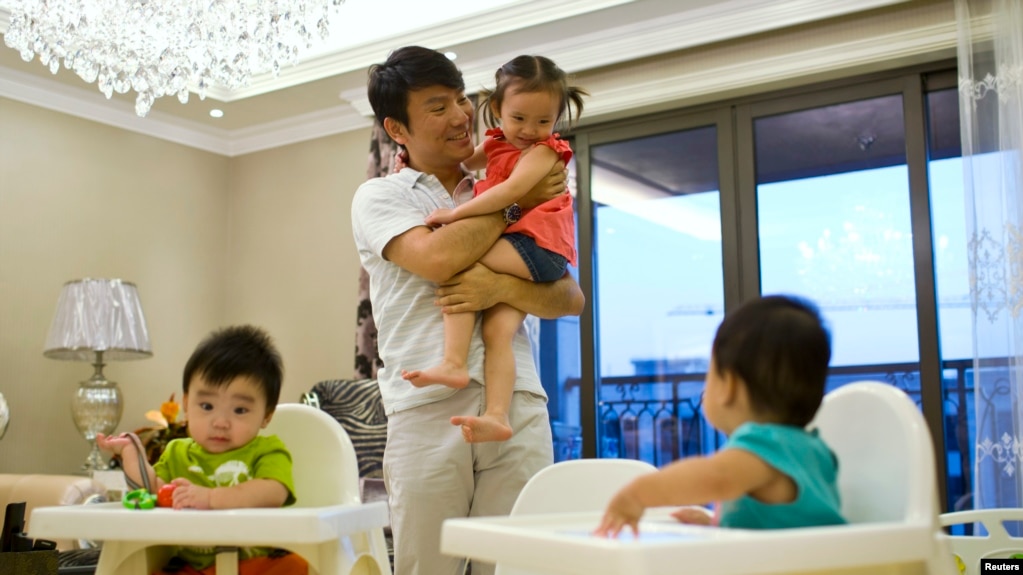 资料照：一位父亲和他的三个孩子在上海家中。（2013年9月16日）(photo:VOA)
