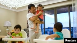 资料照：一位父亲和他的三个孩子在上海家中。（2013年9月16日）