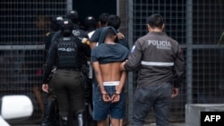 ARCHIVO: Agentes de la Policía Nacional de Ecuador escoltan a varios presuntos miembros de la banda criminal Los Lobos capturados durante una operación el 14 enero de 2024 en Guayaquil.