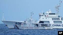 Kapal Penjaga Pantai China menghadang kapal Penjaga Pantai Filipina BRP Malapascua saat bermanuver memasuki muara Second Thomas Shoal yang dikenal masyarakat lokal sebagai Ayungin Shoal di Laut China Selatan pada Minggu, 23 April 2023. (Foto: AP )