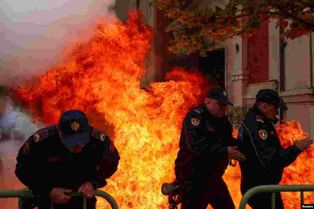 Beberapa polisi bereaksi ketika para pendukung oposisi melemparkan bom molotov ke kantor walikota, menuduhnya melakukan korupsi, di ibu kota Tirana, Albania. (Reuters)&nbsp;