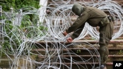 Vojnik KFOR-a postavlja bodljikavu žicu ispred opštine Zvečan