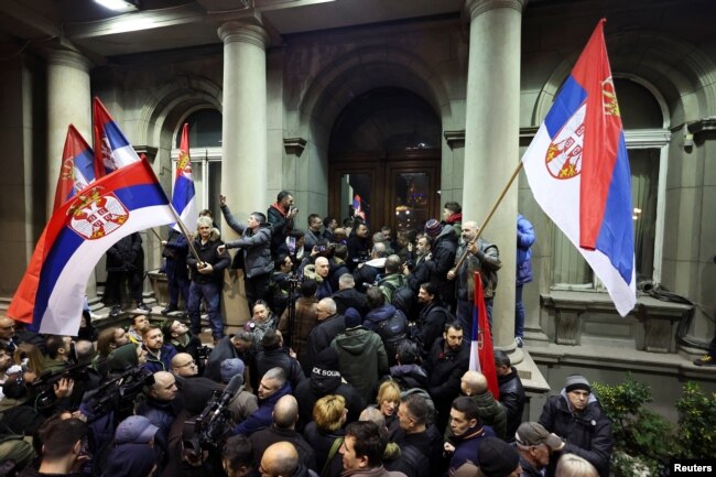 Pristalice opozicione liste "Srbija protiv nasilja" protestuju ispred ulaza u zgradu Skupštine Grada Beograda, u Beogradu, 24. decembra 2023. (Foto: Rojters)