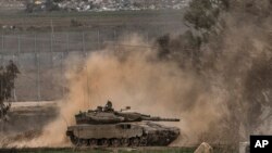 An Israeli army tank moves near the Gaza Strip border, in southern Israel, Dec. 23, 2023. 