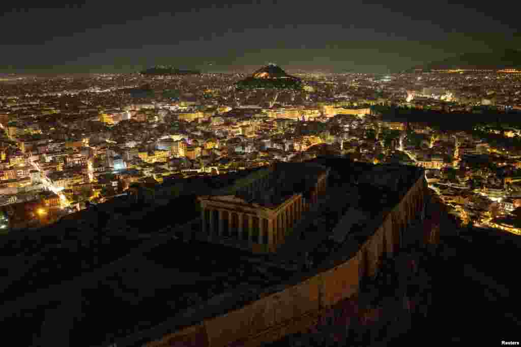 Foto udara dari drone menunjukkan reruntuhan kuil kuno Parthenon di atas bukit Acropolis dengan lampu dimatikan selama Earth Hour, di Athena, Yunani. (Reuters)&nbsp;
