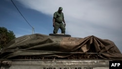 FILE - A member of the Mozambican Forestry Police stands on the top of truck suspected of carrying illegal wood, in Pemba, Cabo Delgado province, Mozambique, Feb. 13, 2017.