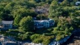 This undated image provided by Vinal Applebee shows the home of Lisa Gorman in the foreground, the poisoned oak trees behind her home, and the home of the perpetrators behind the dead trees, in Camden, Maine.