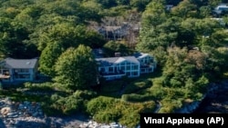 This undated image provided by Vinal Applebee shows the home of Lisa Gorman in the foreground, the poisoned oak trees behind her home, and the home of the perpetrators behind the dead trees, in Camden, Maine.