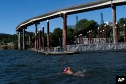 Brian Curtis swims in the Willamette River in Portland, Oregon, July 5, 2024.