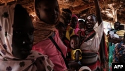 FILE - Mothers wait at a malnutrition centre to register for food aid for their children in the Tiamushro camp for internally displaced persons (IDP) in Kadugli, Sudan, on June 17, 2024.