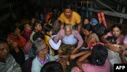 People evacuate on a truck in Sittwe in Myanmar's Rakhine state on May 13, 2023, ahead of the landfall of Cyclone Mocha.