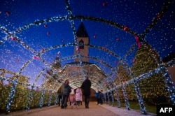 ILUSTRASI - Pengunjung berjalan di bawah dekorasi Natal di gereja Katolik setempat pada malam perayaan Natal di desa Petrushan, dekat kota Gjakova, Kosovo, 18 Desember 2023. (Armend NIMANI / AFP)