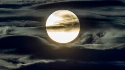 In this Sept. 2, 2020 file photo, the full moon shines surrounded by clouds in the outskirts of Frankfurt, Germany. (AP Photo/Michael Probst, File)