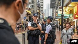 Polisi berpatroli di jalan-jalan di distrik Causeway Bay, Hong Kong, 3 Juni 2024, dekat Taman Victoria, tempat orang-orang biasanya berkumpul setiap tahun pada tanggal 4 Juni untuk berduka atas para korban penumpasan Lapangan Tiananmen di China tahun 1989. (Peter PARKS / AFP)