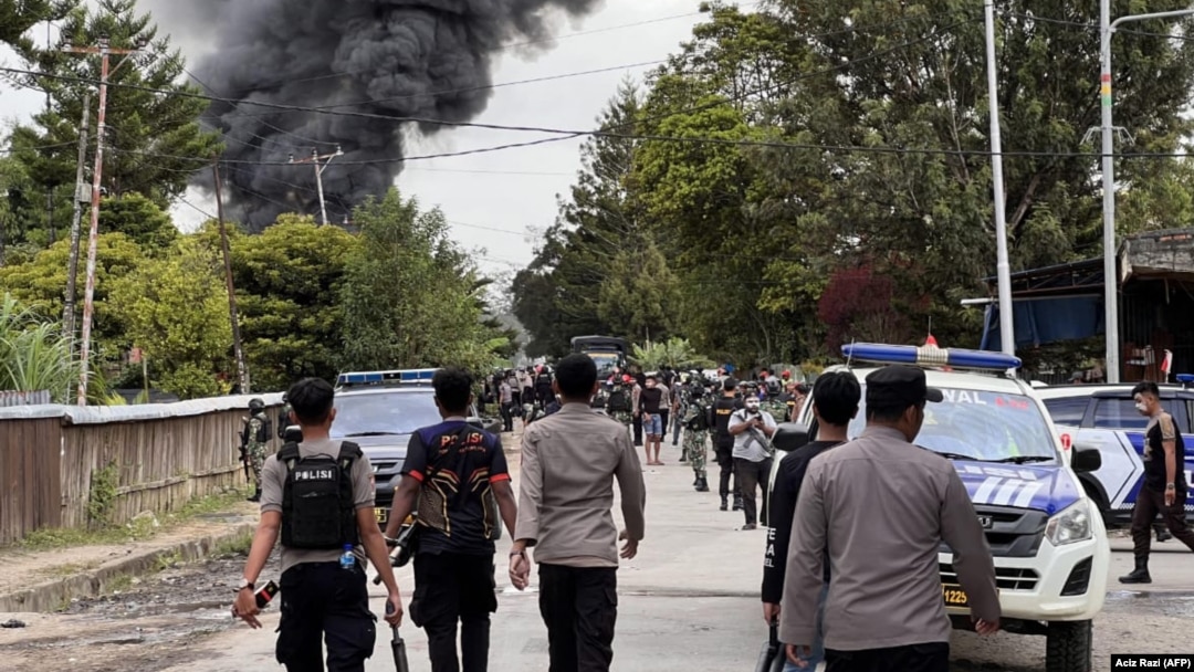 Sejumlah polisi membubarkan massa di Wamena, Papua dalam kerusuhan yang menewaskan 10 orang, Kamis, 23 Februari 2023. Kerusuhan dipicu oleh isu penculikan anak (Foto: Aciz Razi/AFP) 