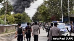 Sejumlah polisi membubarkan massa di Wamena, Papua dalam kerusuhan yang menewaskan 10 orang, Kamis, 23 Februari 2023. Kerusuhan dipicu oleh isu penculikan anak (Foto: Aciz Razi/AFP) 