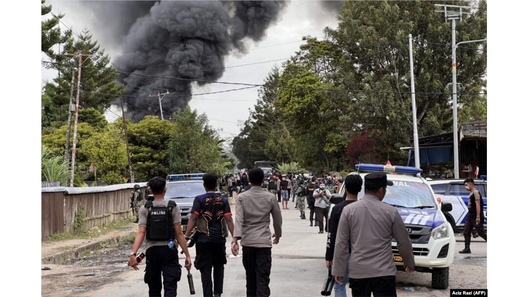 Aparat kepolisian membubarkan warga di Wamena dalam kerusuhan yang dipicu oleh desas-desus penculikan anak. (Foto: AFP/Acis Razi)