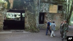 FILE - Tourists visit the ruins of Adolf Hitler's "Wolf's Lair" in Gierloz, Poland, July 17, 2004. Prosecutors have discontinued a probe of skeletons found there because decay made it impossible to determine a cause of death, a spokesman said May 6, 2024.