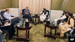 In this photo released by the Taliban Spokesman Office, Zabihullah Mujahid, chief spokesman for the Taliban and head of its delegation, center-right, speaks with Russian envoy to Afghanistan Zamir Kabulov, during a meeting in Doha, Qatar, June 30, 2024.