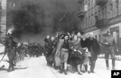 FILE - In this 1943 file photo, a group of Polish Jews are led away for deportation by German SS soldiers during the destruction of the Warsaw Ghetto. (AP Photo, File)