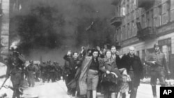 FILE - In this 1943 file photo, a group of Polish Jews are led away for deportation by German SS soldiers during the destruction of the Warsaw Ghetto. (AP Photo, File)