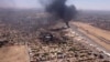 This image grab taken from AFPTV video footage on April 20, 2023, shows an aerial view of black smoke rising above the Khartoum International Airport amid ongoing battles between the forces of two rival generals.