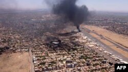 This image grab taken from AFPTV video footage on April 20, 2023, shows an aerial view of black smoke rising above the Khartoum International Airport amid ongoing battles between the forces of two rival generals.