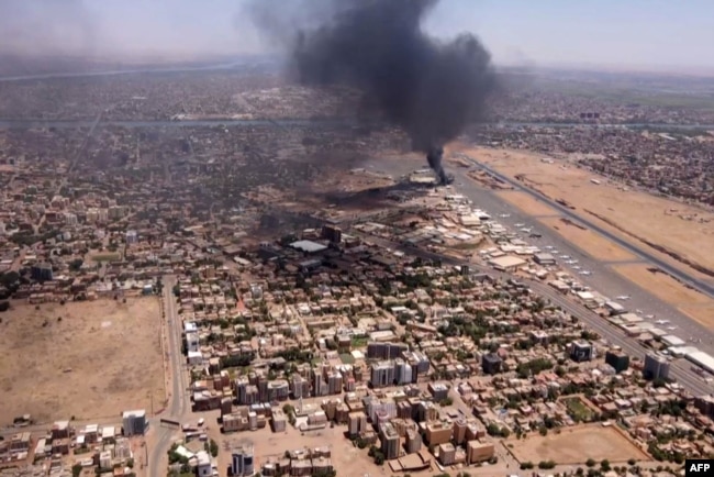 This image grab taken from AFPTV video footage on April 20, 2023, shows an aerial view of black smoke rising above the Khartoum International Airport amid ongoing battles between the forces of two rival generals.