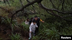 一家來自中國的移民渡過美墨邊境的格蘭德河正在走出美國德克薩斯州的叢林。（資料照片，2023年4月4日）