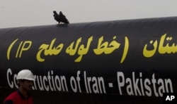 Seorang pekerja Iran berjalan melewati Proyek Pipa Gas Pakistan-Iran di Gabd dekat perbatasan Pakistan di Iran, Senin, 11 Maret 2013. (AP Photo/B.K. Bangash)