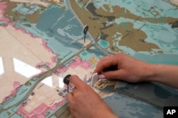 A woman sets an installation part of "Coastal Imaginaries" at the Denmark pavilion, at the Biennale International Architecture exhibition, in Venice, Italy, May 17, 2023.