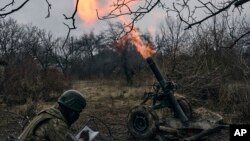 Soldados voluntarios disparan hacia posiciones rusas cerca de Bakhmut, región de Donetsk, Ucrania, el miércoles 8 de marzo de 2023.