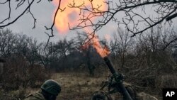 Soldados voluntários disparam para posições russas perto de Bakhmut, região de Donetsk, Ucrânia, quarta-feira, 8 de Março de 2023. 