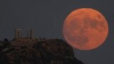 The supermoon rises behind the ancient temple of Poseidon at Cape Sounion, about 70 kilometers (45 miles) south of Athens, Greece, Aug. 30, 2023. 