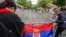 Žene kače srpsku zastavu na ogradu tokom protesta u Zvečanu, 31. maj 2023.