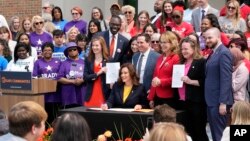 FILE - Michigan Gov. Gretchen Whitmer signs legislation in Royal Oak, Michigan, May 22, 2023. Fueled by election gains, Democrats in Minnesota and Michigan this year enacted far-reaching policy changes that party leaders aspire to replicate elsewhere.