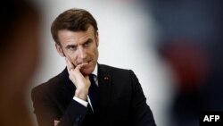 FILE - French President Emmanuel Macron gestures as he speaks with schoolchildren in a classroom as he visits the Jean Lartaut Middle School in Jarnac, western France, Feb. 28, 2023.