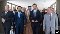 In this photo released by the official Telegram account of the Syrian Presidency, Syrian President Bashar Assad walks with a delegation representing various Arab parliaments in Damascus, Feb. 26, 2023. (Syrian Presidency via Telegram via AP)