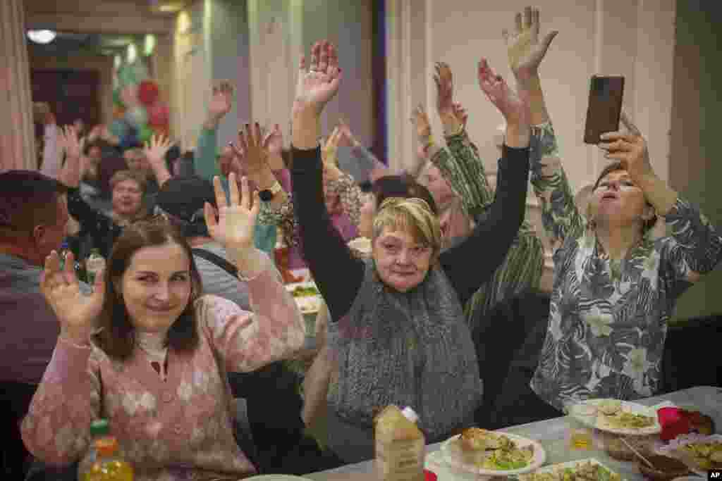 Mujeres de la comunidad judía ucraniana levantan la mano al ritmo de la música durante las celebraciones de Purim (Foto AP/Vadim Ghirda)