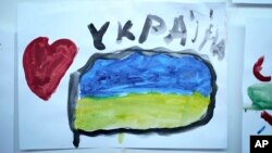 Un dibujo con un corazón y una bandera ucraniana hecho por un niño refugiado que huyó de la guerra en Ucrania fue colocado en una pared del campamento de refugiados en el centro nacional de exposiciones MoldExpo en Chisinau, Moldavia, el 15 de marzo de 2022.