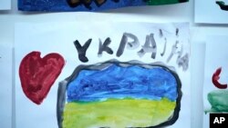 Un dibujo con un corazón y una bandera ucraniana hecho por un niño refugiado que huyó de la guerra en Ucrania fue colocado en una pared del campamento de refugiados en el centro nacional de exposiciones MoldExpo en Chisinau, Moldavia, el 15 de marzo de 2022.