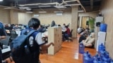 FILE - In this photo provided by the Philippine National Police Anti-Cybercrime Group, police enter an office they raided in Las Pinas, Philippines, June 27, 2023. Journalists reporting on illicit activity connected to scam centers in Cambodia say they face security risks. 