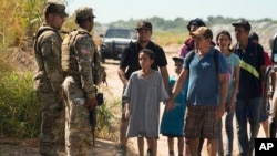 Para migran yang menyeberang dari Meksiko ke Amerika serikat diarahkan menuju pusat-pusat imigrasi di Eagle Pass, Texas, Kamis, 21 September 2023. (Foto: Eric Gay/AP Photo)