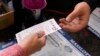 FILE - A customer purchases five Powerball tickets Oct. 10, 2023, in Haverhill, Mass. 