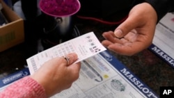 FILE - A customer purchases five Powerball tickets Oct. 10, 2023, in Haverhill, Mass. 