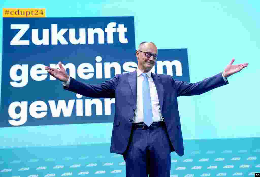 Christian Democratic Party leader Friedrich Merz reacts at a CDU party convention in Berlin, Germany. Letters read "win future together." 