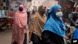 Women, wearing masks, visit a market in Lahore, Pakistan, Jan. 15, 2024. 