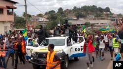 FILE - This image taken from video shows coup supporters cheering police officers in Libreville, Gabon, on Aug. 30, 2023.