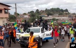 This image taken from video shows coup supporters cheering police officers in Libreville, Gabon, Aug. 30, 2023.